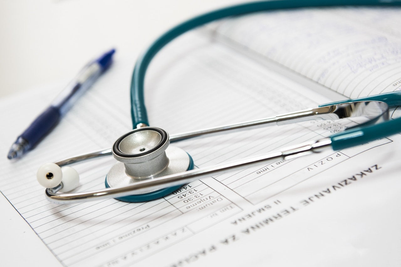 medical stethoscope on top of a stack of papers