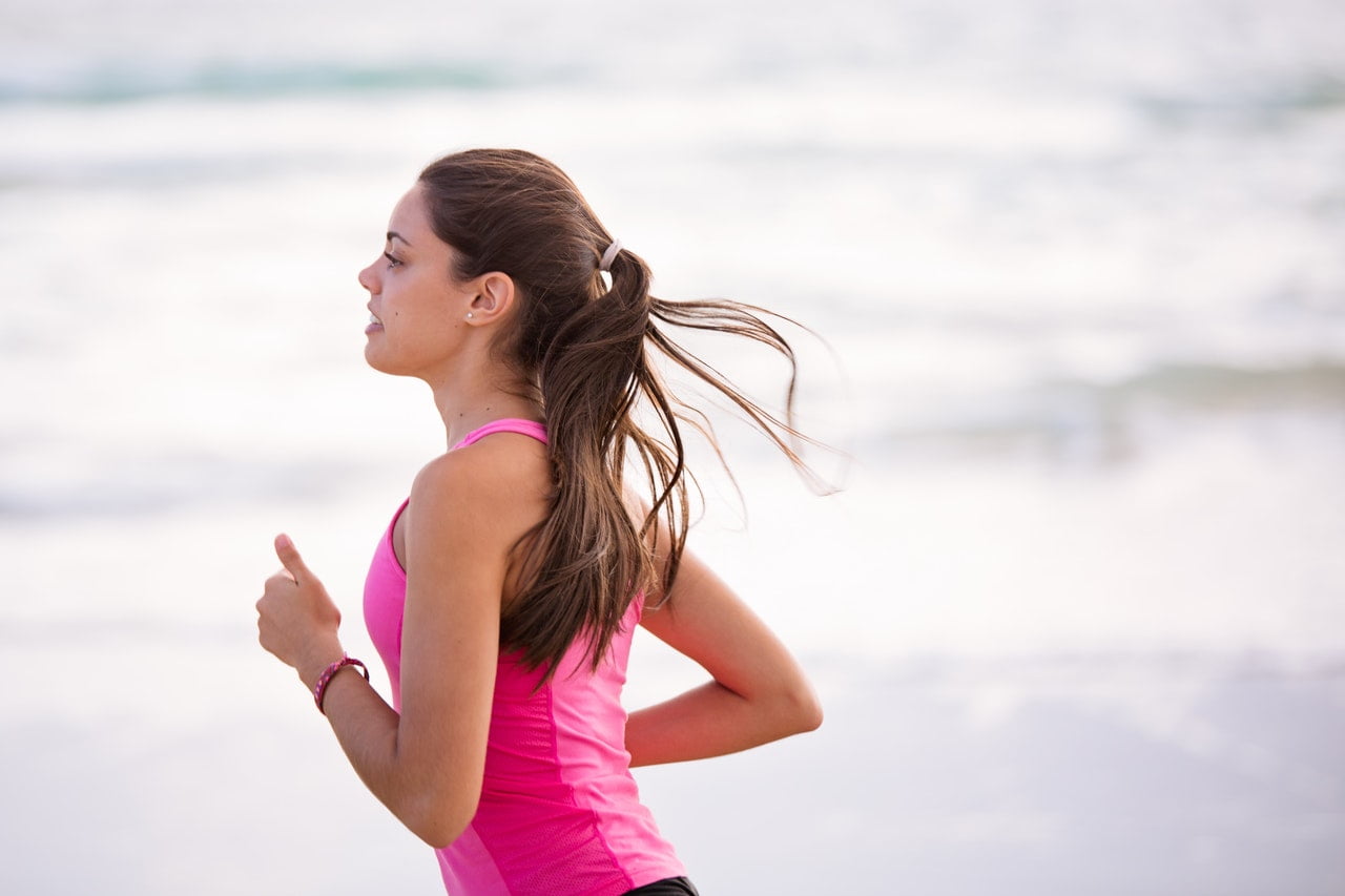 a woman in a pink dress on a beach